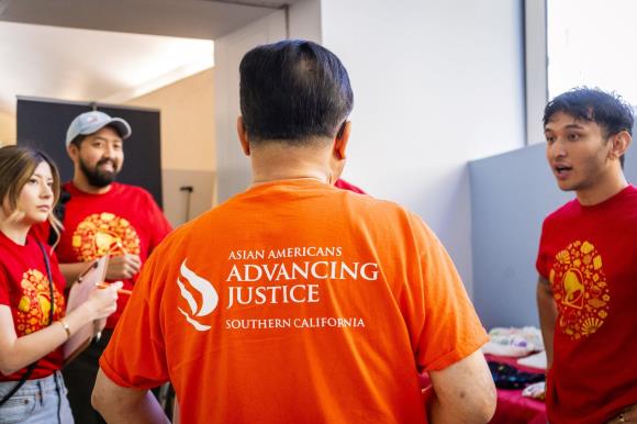 A group of men in orange shirts

Description automatically generated