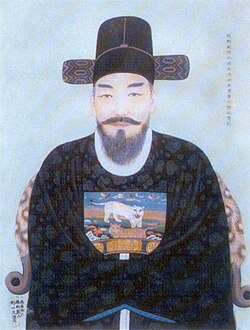 A person wearing a hat and a black robe

Description automatically generated