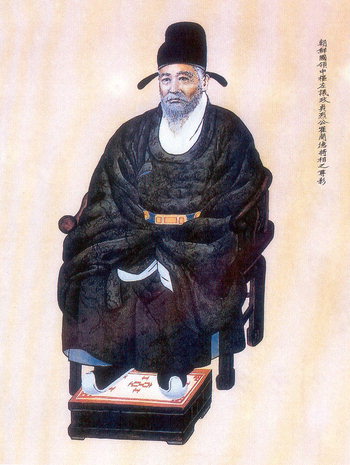 A person in a black robe sitting on a chair

Description automatically generated